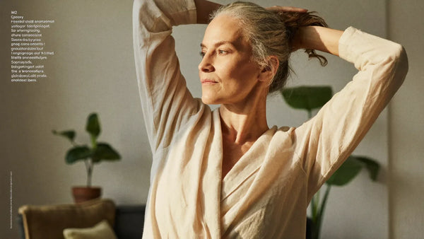 Femme de 50 ans étirant ses bras dans une lumière dorée — douleurs articulaires et ménopause, solutions naturelles